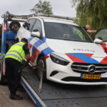 Politiewagen rijdt tegen stoep, auto afgesleept